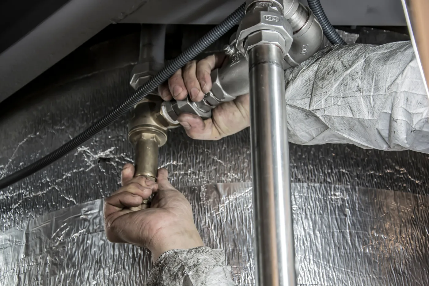 A plumber's hands fitting pipework